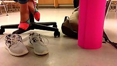 Teen school girl takes her shoes off after gym class